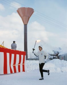 Sapporo 1972 Winter OG - A relay runner in front the cauldron of the Eniwa mountain.